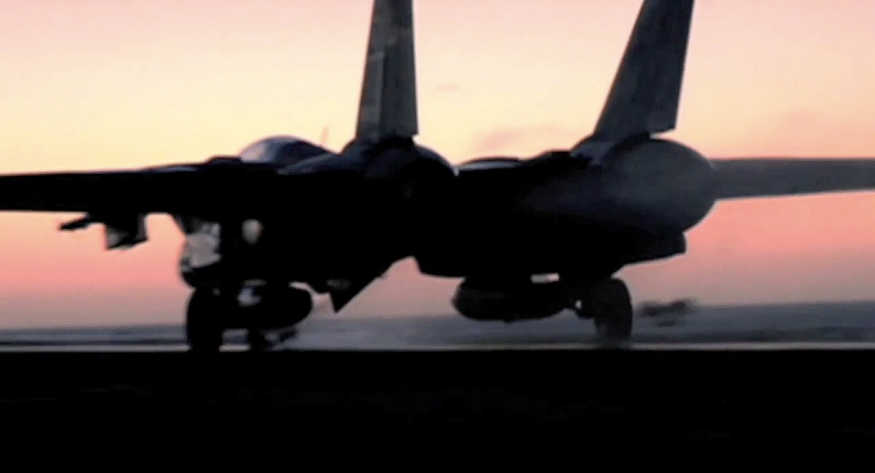 Navy F-14 fighter jet taking off into the sunset